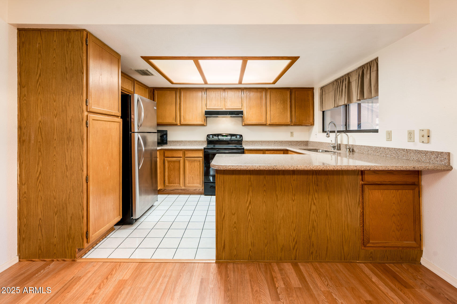 538 South 76th Place Mesa, AZ 85208 - Photo 8 of 50 a kitchen with stainless steel appliances granite countertop a refrigerator a sink dishwasher a stove with wooden cabinets and floor