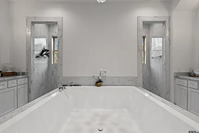 a bathroom with a granite countertop sink and bathtub