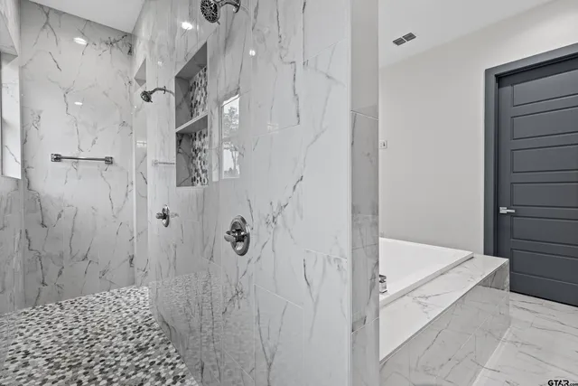 an empty room with wooden floor chandelier fan and windows