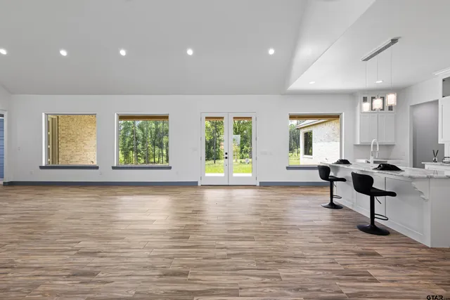 a kitchen with stainless steel appliances kitchen island hardwood floor and a window