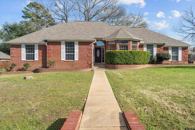 a front view of a house with a yard and potted plants