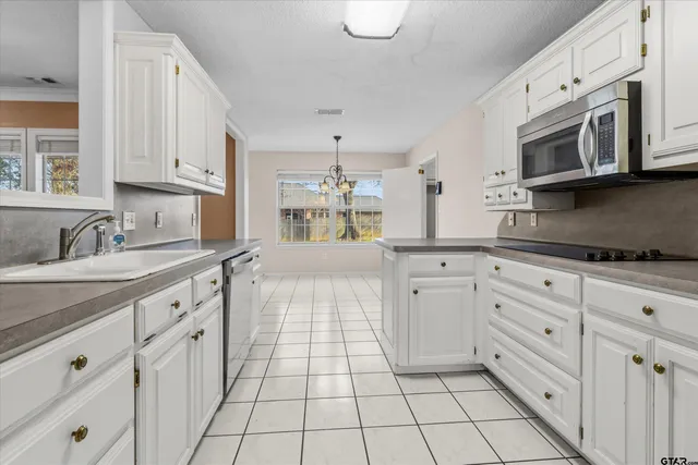 a kitchen with stainless steel appliances white cabinets and a sink