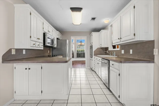 a kitchen with granite countertop a sink a stove and cabinets