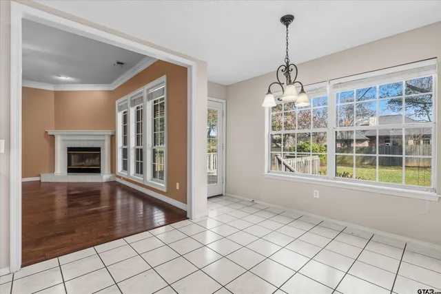 a view of an empty room with window wooden floor and fire place