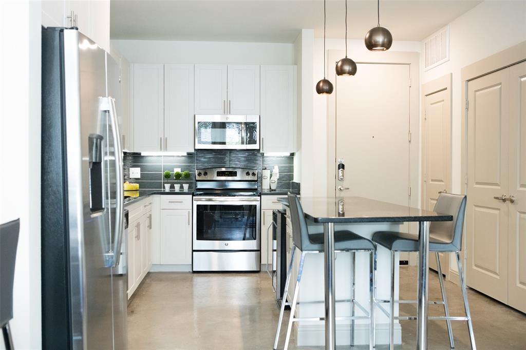 7606 Eastern Avenue, Unit 301 Dallas, TX 75209 - Photo 2 of 5 a kitchen with stainless steel appliances a refrigerator a stove and white cabinets