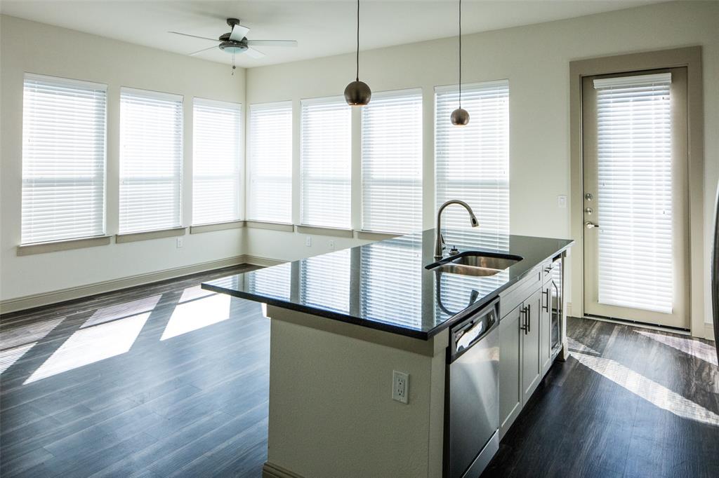 7606 Eastern Avenue, Unit 301 Dallas, TX 75209 - Photo 5 of 5 a kitchen with granite countertop a stove a sink a refrigerator and wooden floor