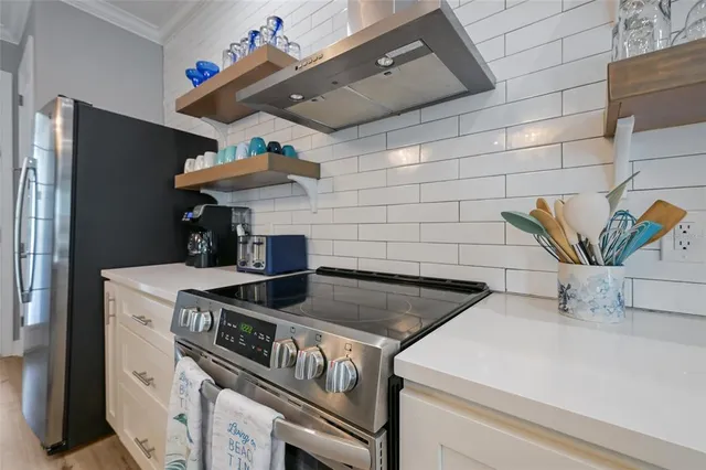 a kitchen with a sink dishwasher and white cabinets with wooden floor