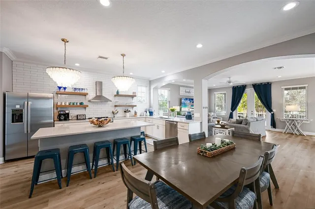 a view of a dining room and livingroom with furniture wooden floor a chandelier