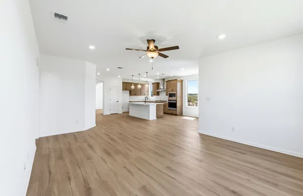 a large kitchen with stainless steel appliances a large counter top a refrigerator and a sink