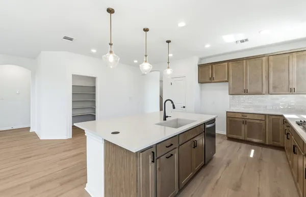 a large kitchen with stainless steel appliances kitchen island a large counter top and a wooden floors