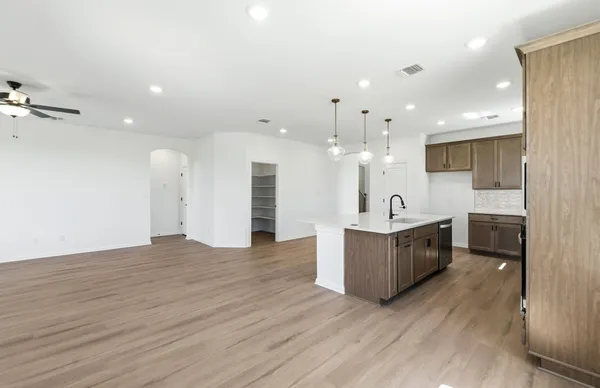 a kitchen with a sink stove and wooden floor