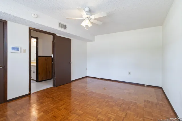 an empty room with closet and a ceiling fan