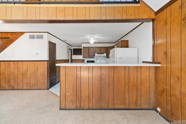 a kitchen with kitchen island granite countertop wooden cabinets and sink