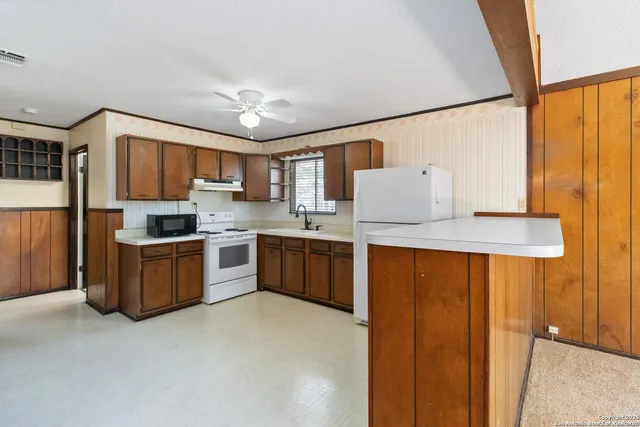 a kitchen with stainless steel appliances granite countertop a refrigerator and a stove top oven