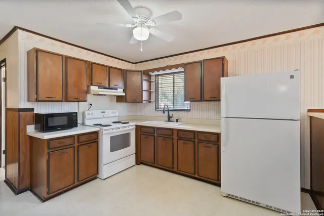 a kitchen with a refrigerator sink and cabinets