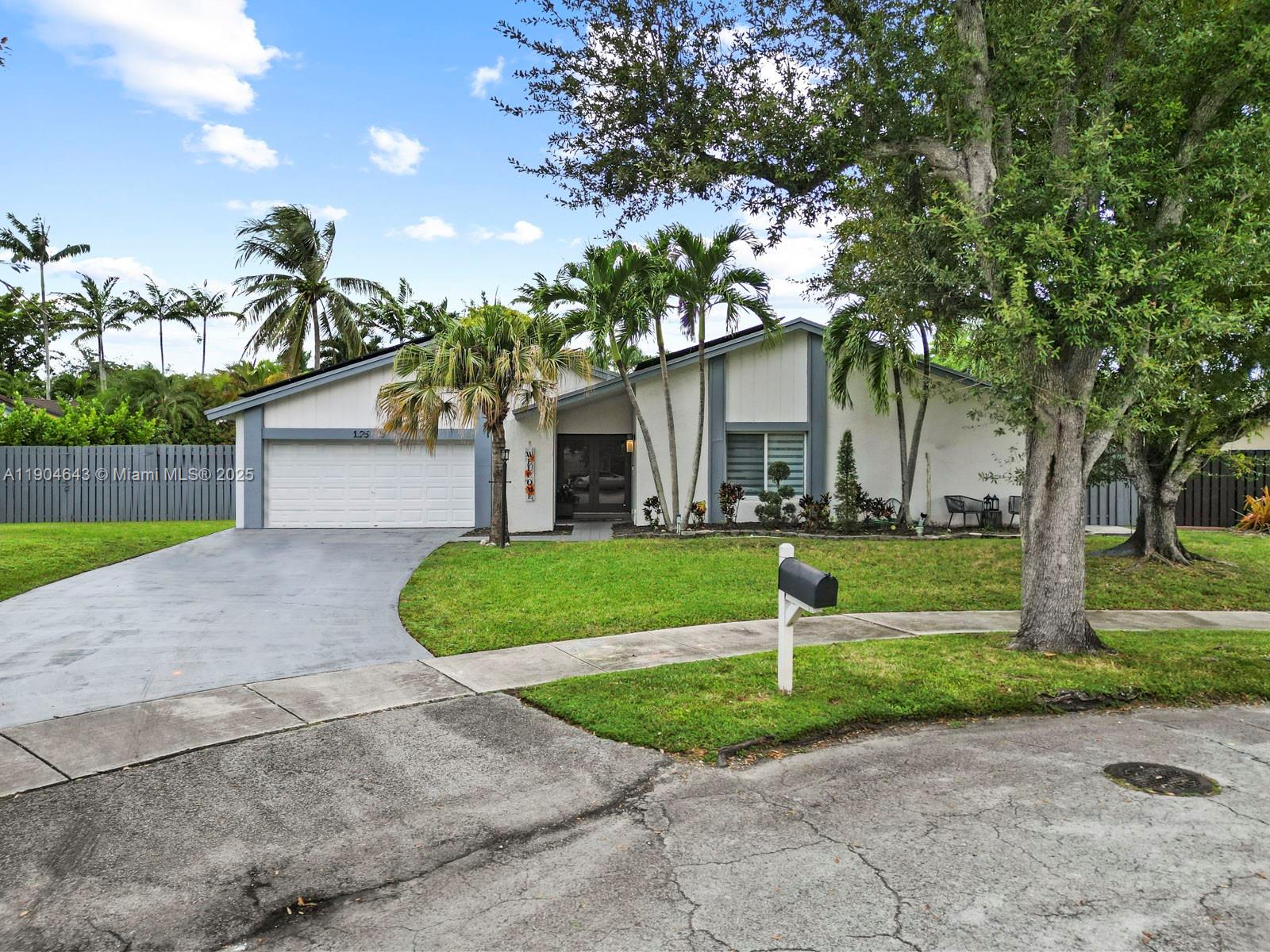a front view of a house with a yard and a garage