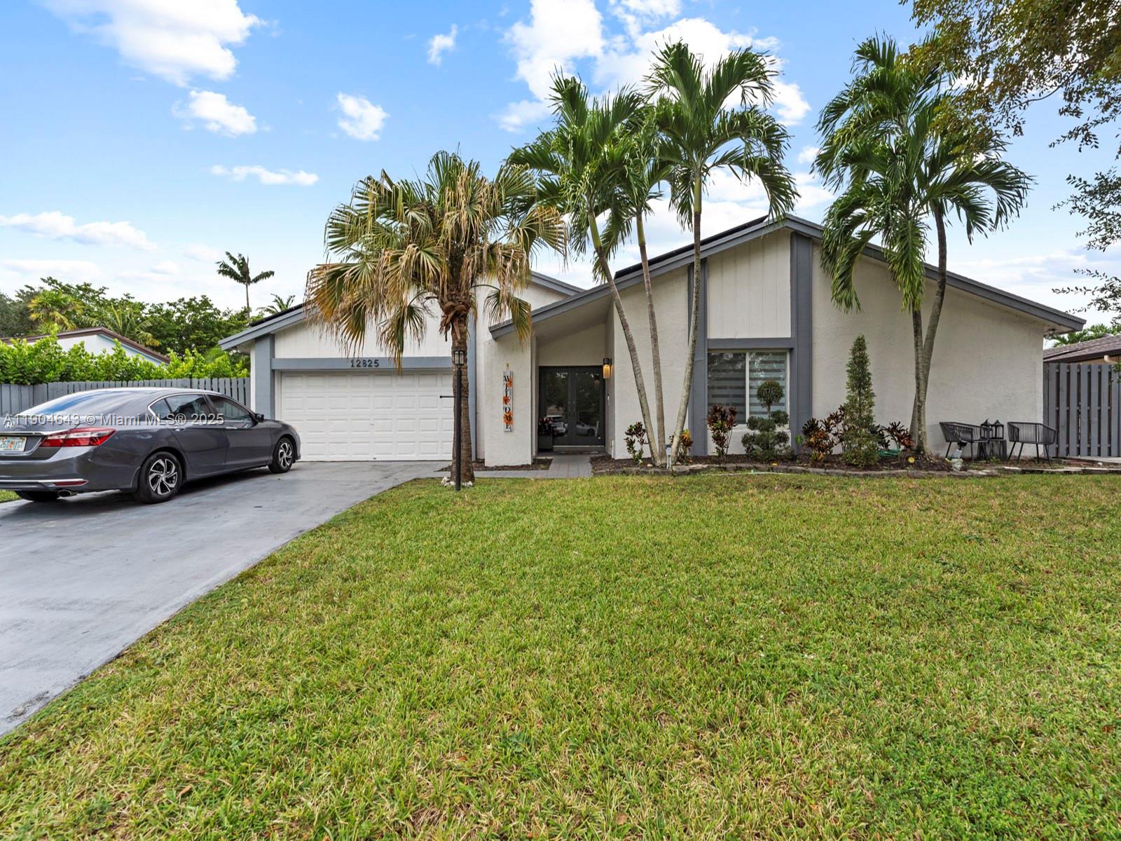 12825 Southwest 107th Terrace Miami, FL 33186 - Photo 2 of 43 a front view of a house with garden