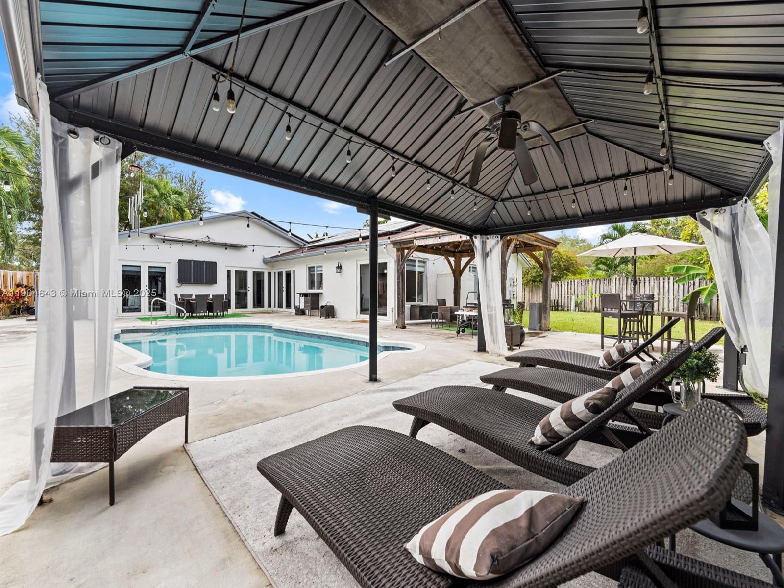 12825 Southwest 107th Terrace Miami, FL 33186 - Photo 39 of 43 a view of a patio with table and chairs with wooden floor and fence