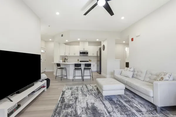 a kitchen with stainless steel appliances a white table chairs and a refrigerator