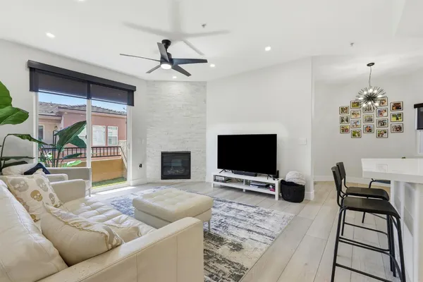 a kitchen with a sink a counter top space and living room view