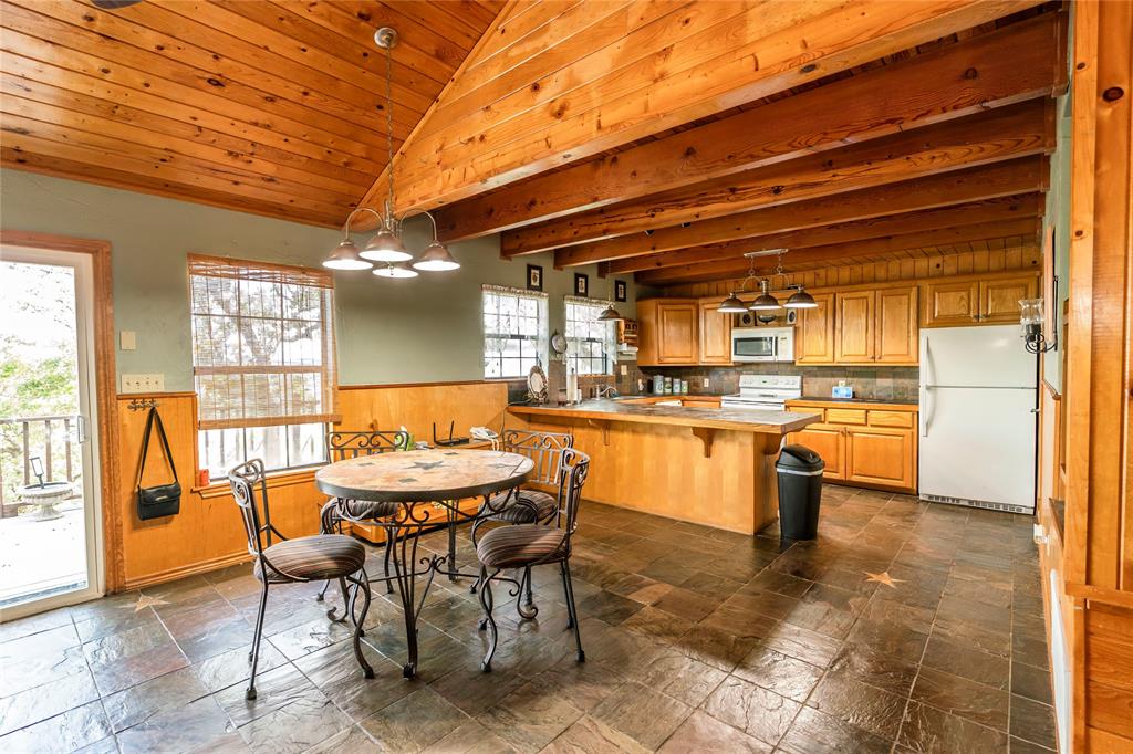 698 Storey Road Nocona, TX 76255 - Photo 32 of 34 Dining area featuring wooden walls, a wainscoted wall, and wood ceiling