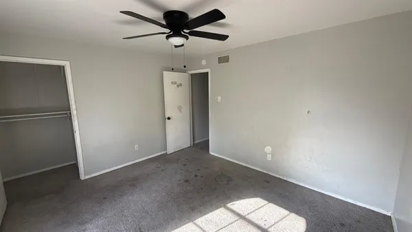 a view of a big room with wooden floor and a ceiling fan in a room