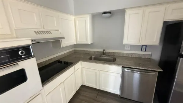 a kitchen with white cabinets and appliances