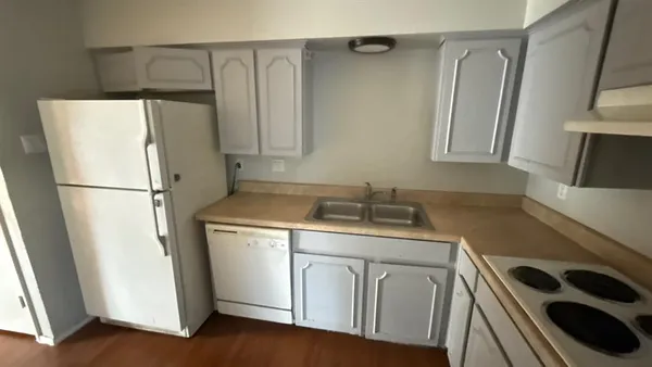 a kitchen with a refrigerator sink stove and cabinets