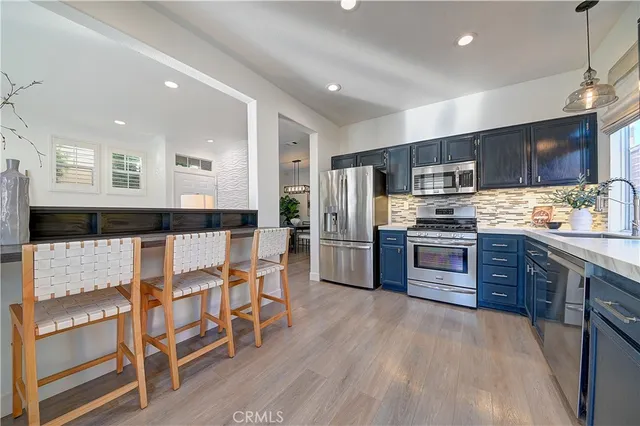 a kitchen with stainless steel appliances granite countertop wooden cabinets a stove and a sink