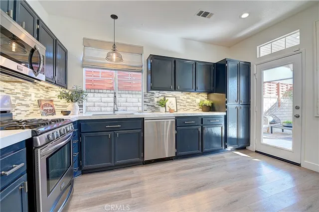 a kitchen with stainless steel appliances granite countertop a refrigerator stove and sink
