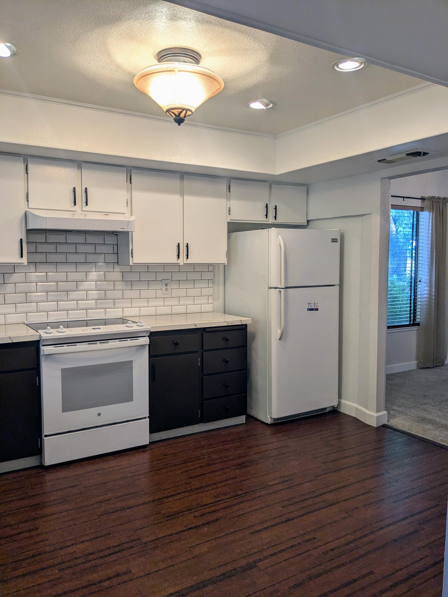 1974 Bechelli Lane Redding, CA 96002 - Photo 19 of 49 a kitchen with wooden floors and white appliances