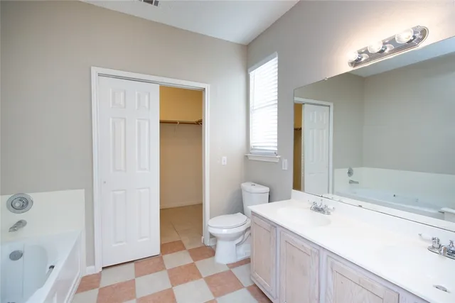a spacious bathroom with a sink a toilet a shower and a large mirror