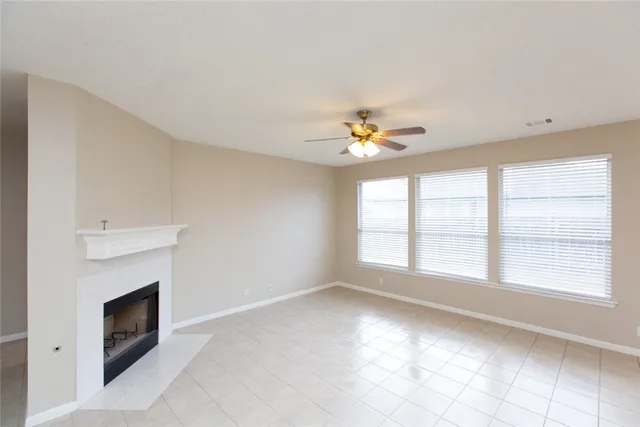 a view of an empty room with a fireplace and a window