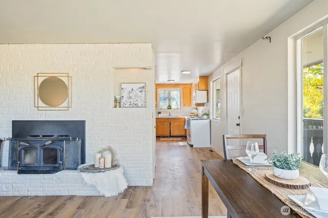 a kitchen with a sink wooden floor and white appliances