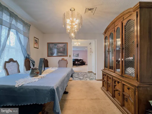 a view of a dining room with furniture and a chandelier