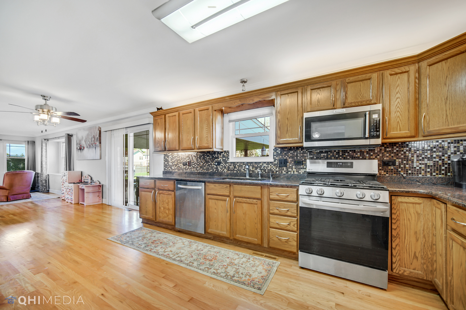 7930 Farmhouse Road Frankfort, IL 60423 - Photo 8 of 24 a kitchen with stainless steel appliances granite countertop a stove a sink and a microwave