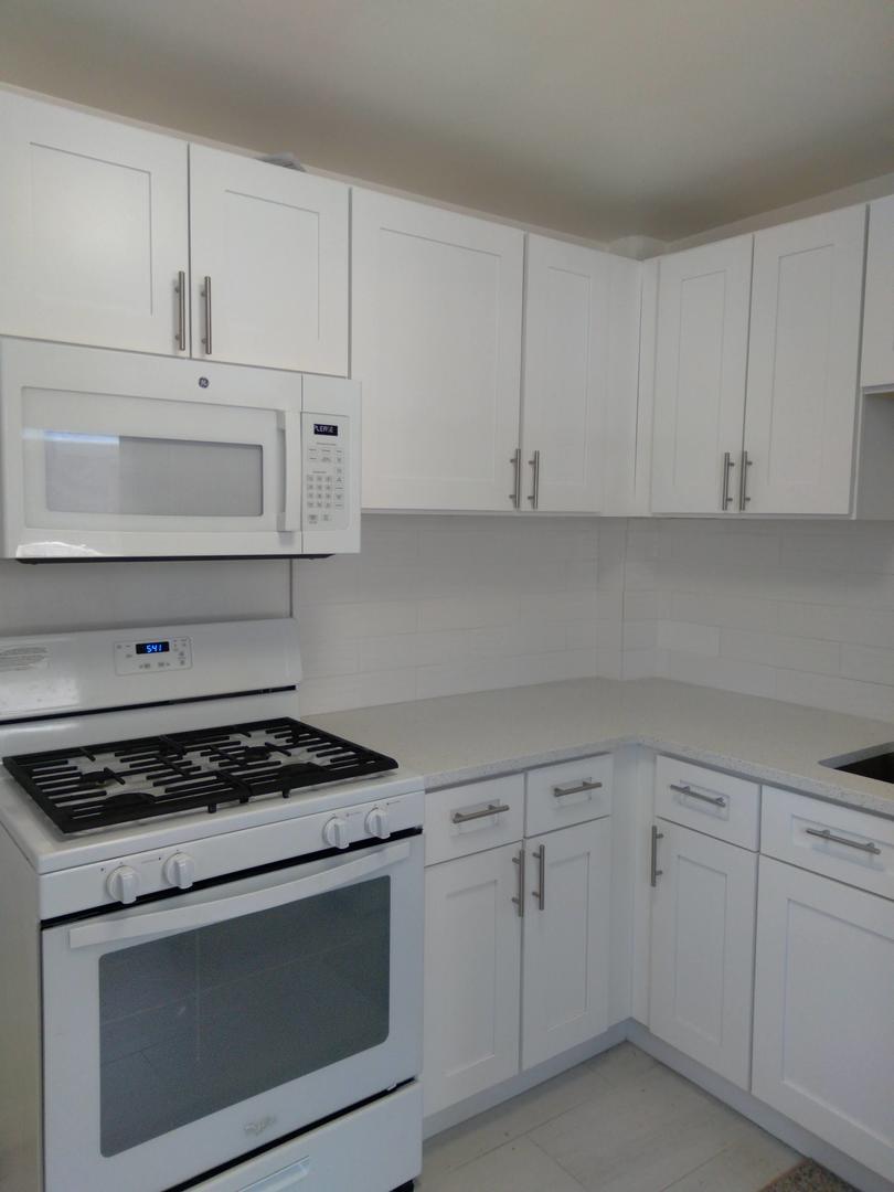 907 Austin Street, Unit 2 Evanston, IL 60202 - Photo 3 of 9 a kitchen with white cabinets and appliances
