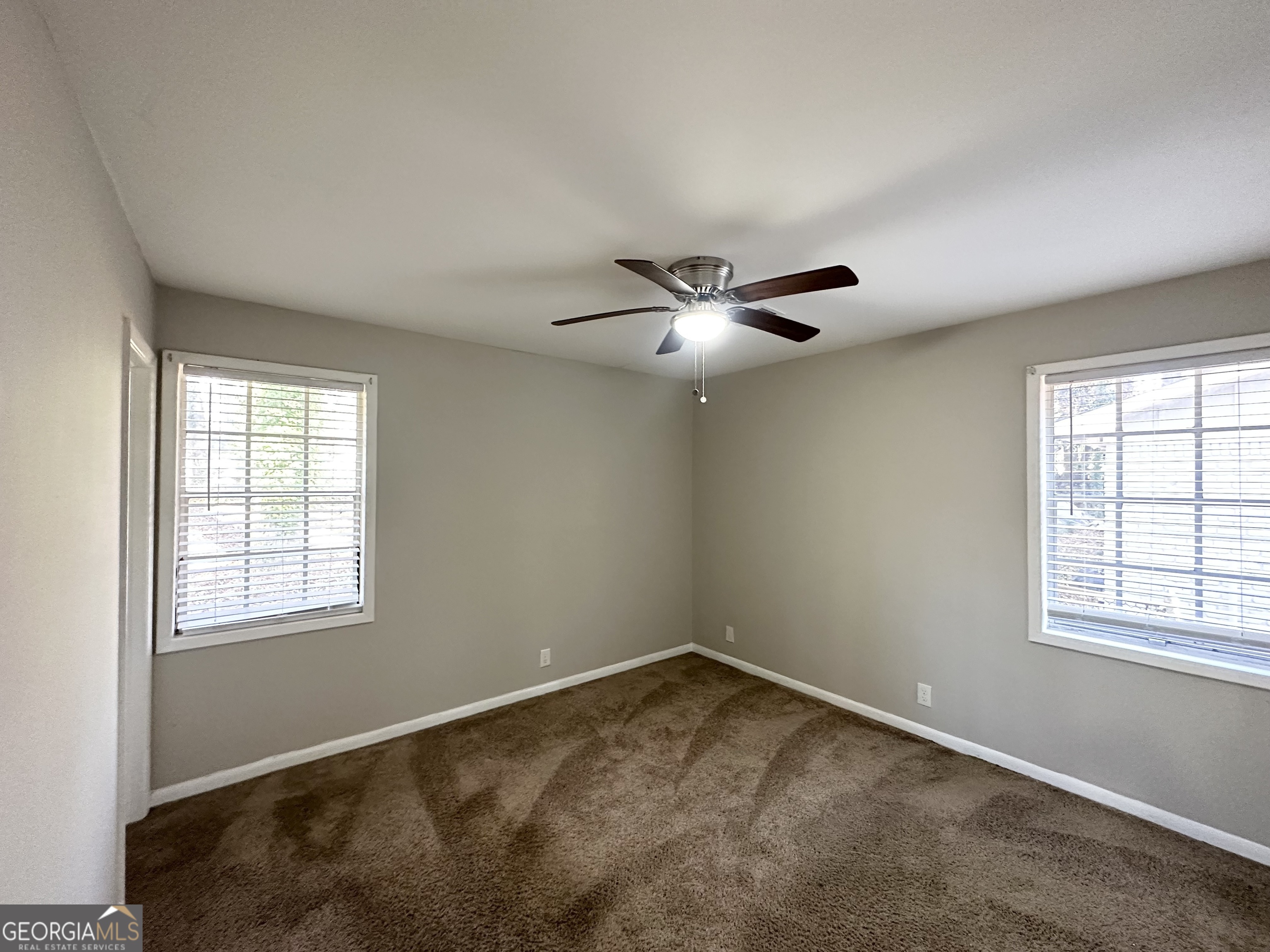 4448 Malibu Drive Decatur, GA 30035 - Photo 5 of 7 an empty room with windows and fan