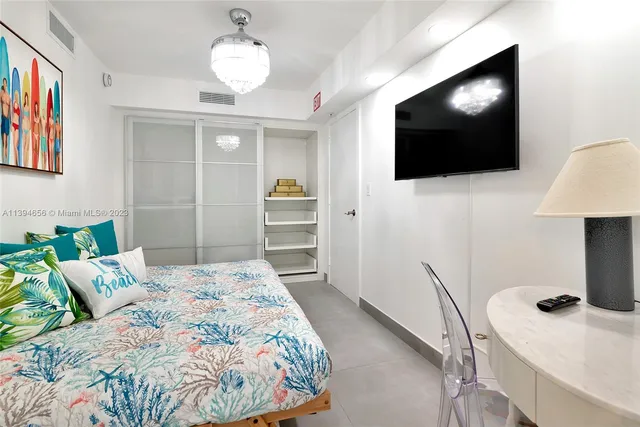 a bedroom with a bed and a flat screen tv