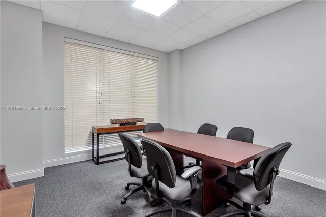 a view of a workspace with furniture and a window