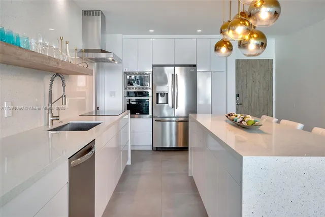 a kitchen with stainless steel appliances kitchen island granite countertop a sink refrigerator and microwave