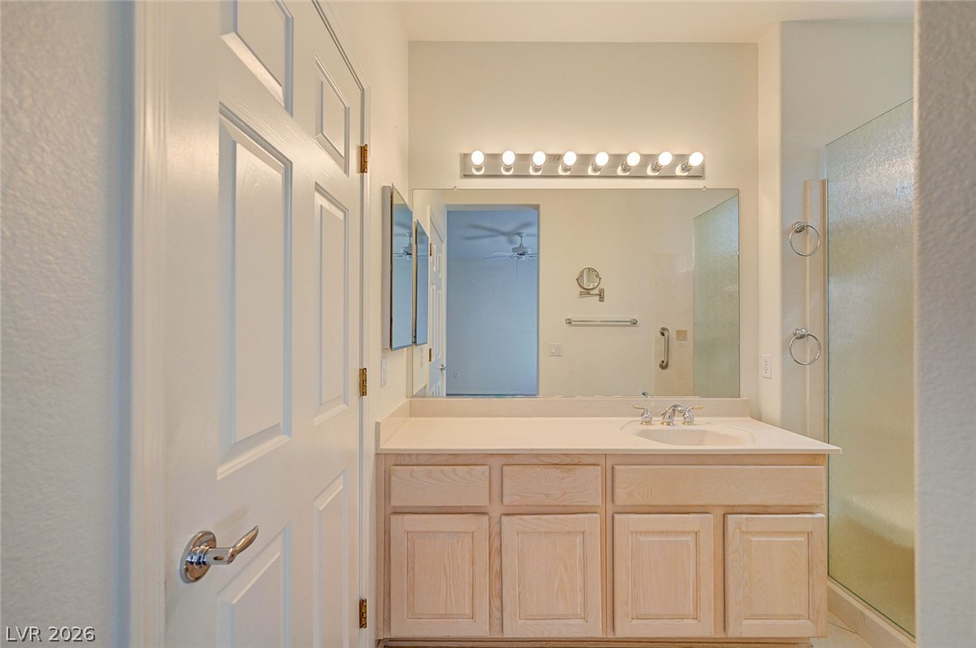 2529 Springville Way Henderson, NV 89052 - Photo 34 of 70 High ceilings and a wood vanity define this clean, neutral bathroom space.