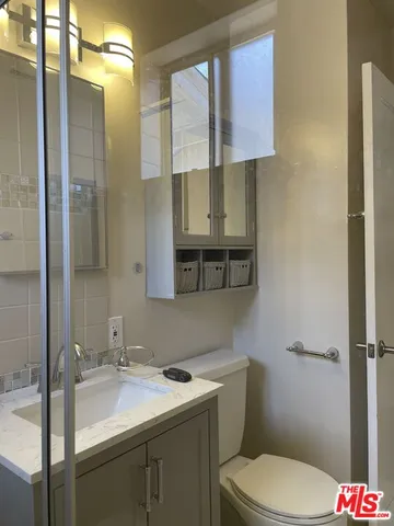 a bathroom with a sink toilet vanity and shower
