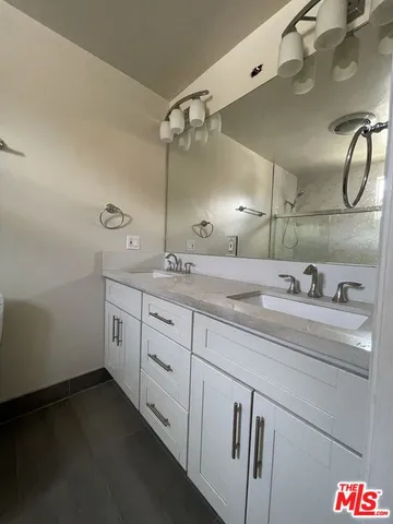 a spacious bathroom with a double vanity sink and mirror