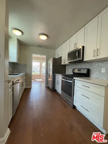 a kitchen with stainless steel appliances a stove sink microwave and cabinets