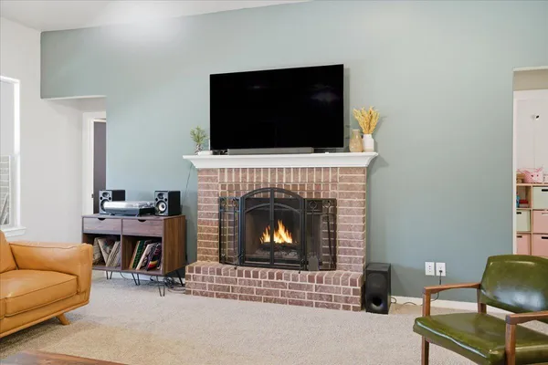 a living room with furniture a flat screen tv and a fireplace