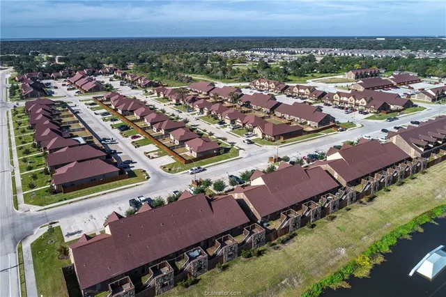 an aerial view of a city with lots of residential buildings and ocean view in back