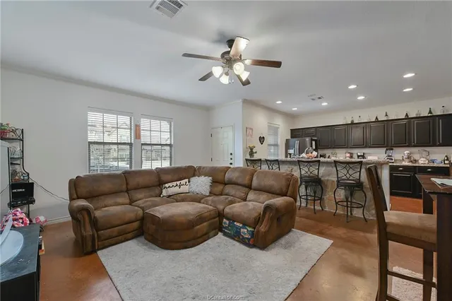 a living room with furniture and kitchen view
