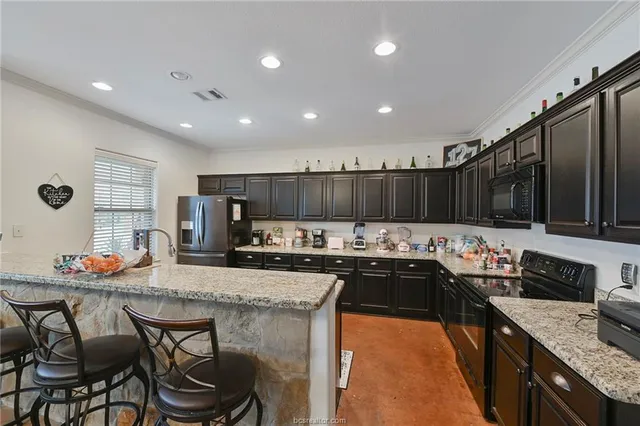 a kitchen with stainless steel appliances granite countertop a stove a sink and a refrigerator