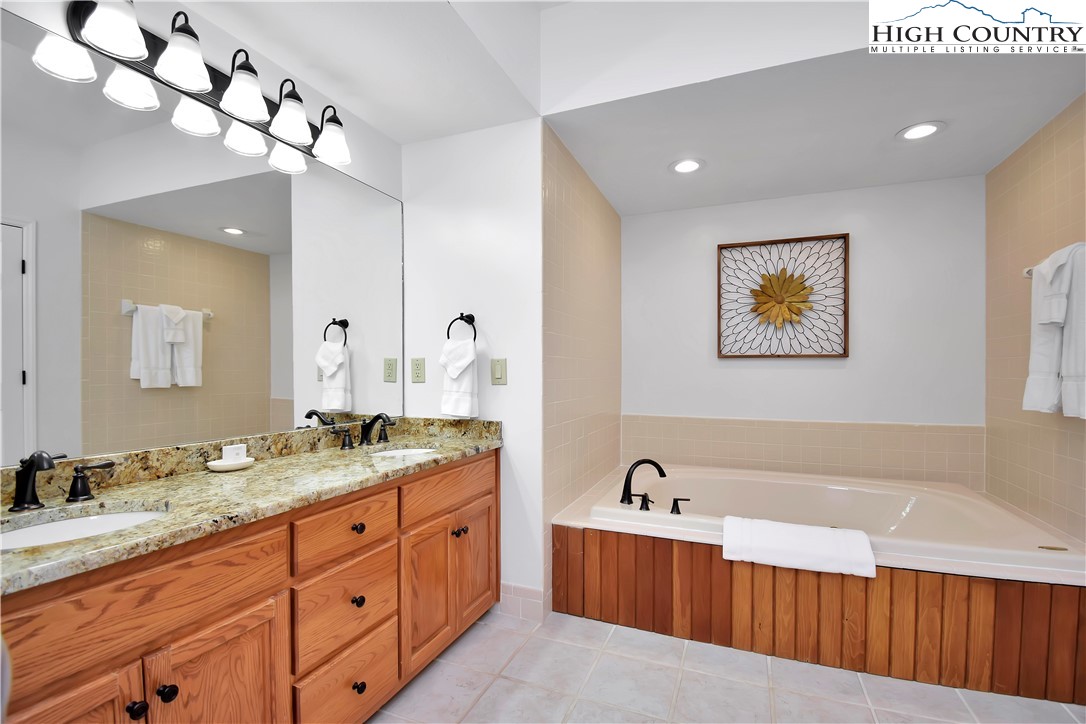 140 Manor View Lane, Unit CASCADES 2 Blowing Rock, NC 28605 - Photo 15 of 25 a spacious bathroom with a tub double sink and mirror